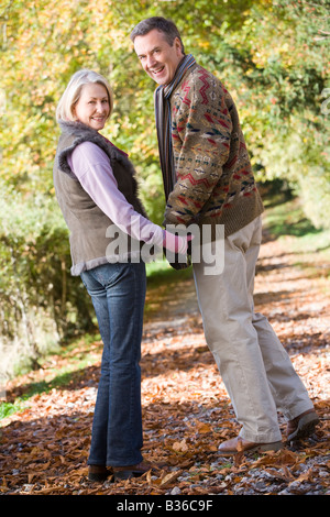 Giovane all'aperto sul percorso nel parco si tengono per mano e sorridente (messa a fuoco selettiva) Foto Stock