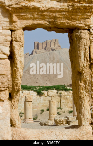 Il castello arabo Qalaat Ibn Maan attraverso le rovine Romane di Palmyra in Siria Foto Stock