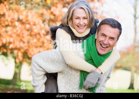 Senior all'esterno uomo donna piggybacking e sorridente (messa a fuoco selettiva) Foto Stock
