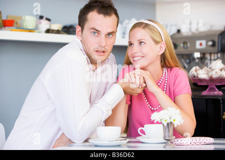 Coppia giovane seduti ad un tavolo e avente il tè insieme Foto Stock