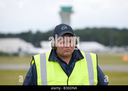 La guardia di sicurezza con gli otoprotettori a Farnborough International Airshow di luglio 2008 Foto Stock