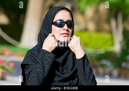 Teenage ragazza iraniana indossando occhiali da sole e regolando il suo velo presso la tomba di Hafez a Shiraz Iran Foto Stock