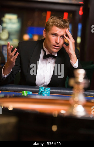 Uomo in casinò giocare alla roulette e perdere (messa a fuoco selettiva) Foto Stock