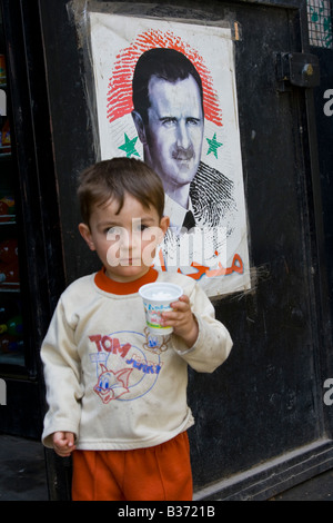 Giovane ragazzo siriano e un poster di Bashar Assad di Aleppo Siria Foto Stock