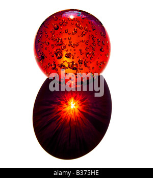 Il fuoco di un tramonto è rappresentato da rifrangere i raggi attraverso una sfera di vetro Foto Stock