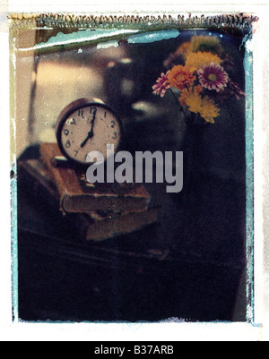 Immagine pittorica del clock sulla sommità di libri vecchi seduti a un tavolo con un vaso con fiori Foto Stock