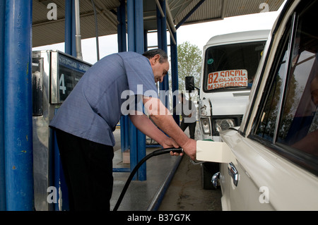 L'uomo riempiendo la sua vettura a benzina in corrispondenza di una stazione di riempimento di Tbilisi, capitale della Repubblica di Georgia Foto Stock