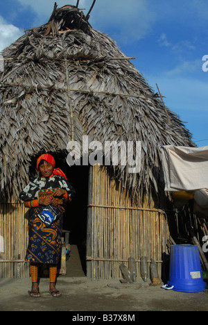 Il sambuco Kuna donna indiana di fronte casa di paglia, Rio Sidra area, Arcipelago San Blas, Panama America Centrale Foto Stock