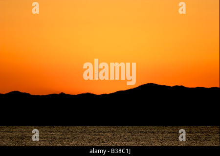 Un bel cielo arancione si accende appena prima del tramonto sull isola Texada nello Stretto di Georgia in British Columbia in Canada. Foto Stock