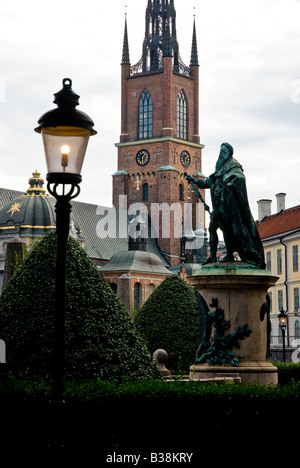 La statua del re Gustav Vasa i fuori Riddarhuset a Stoccolma. Sullo sfondo la chiesa Riddarholmskyrkan Foto Stock