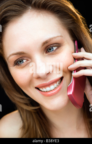 Close up ritratto di Giovane femmina adulta parlando al telefono cellulare e sorridente Foto Stock