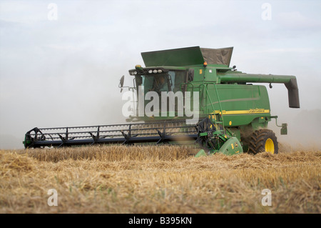 Mietitrebbia John Deere la raccolta di frumento invernale in condizioni polverose Foto Stock