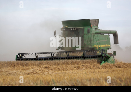 Mietitrebbia John Deere la raccolta di frumento invernale in condizioni polverose Foto Stock