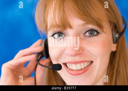 Giovane imprenditrice che indossa la cuffia e sorridente Foto Stock