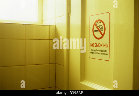 Cartello sulla porta di legno in mattonelle bianche in camera calda luce dicendo con icona fumare non è contro la legge di fumare in questi locali Foto Stock