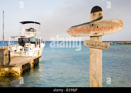 In barca e a signpost Piscadera Bay beach Curaçao Antille olandesi Caraibi Foto Stock