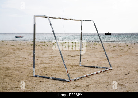 Vecchio arrugginito obiettivo di calcio sulla spiaggia vuota che si affaccia sull'oceano. Foto Stock