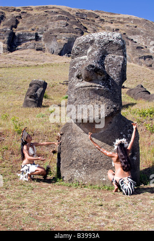 Ballerini di Rapa Nui in costume tradizionale presso l'antica testa di pietra gigante nella cava di Rano Raraku Moai sull'isola di Pasqua Foto Stock