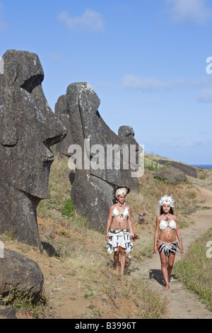 Donne Rapa Nui, isolani in costume tradizionale camminando lungo il sentiero attraverso la cava di Rano Raraku moai sull'Isola di Pasqua Foto Stock