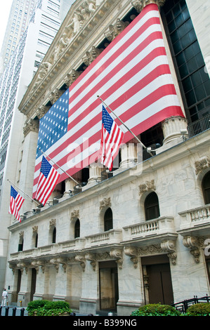 New York Stock Exchange American Flag facciata New York City // NEW YORK CITY, New York — la facciata neoclassica della Borsa di New York è decorata con una massiccia bandiera americana. Le stelle e le strisce si infrangono in modo drammatico attraverso le colonne iconiche, simboleggiando l'intersezione del patriottismo americano e della finanza globale a Wall Street. Foto Stock