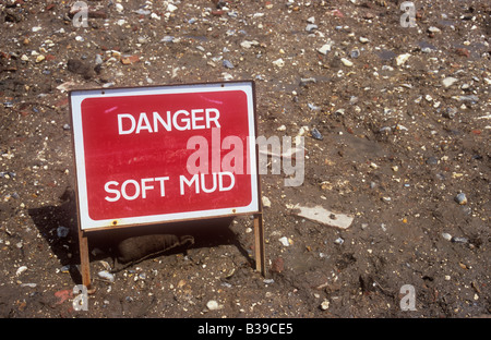 Il bianco e il rosso roadworks segno impostato in banca di terra con macerie miscelati in indicando pericolo fango morbido Foto Stock