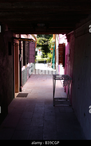 Un passaggio (arcade) tra le case colorate lungo il canale/canali di Burano Venezia, Italia 14 Agosto 2008 Foto Stock