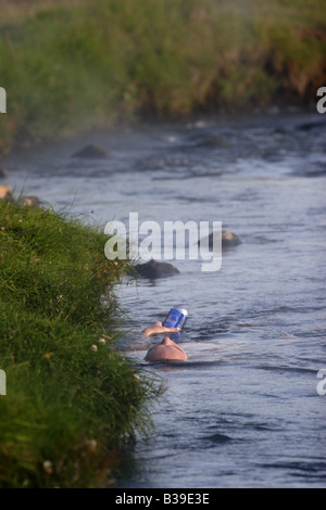 Un uomo bagni in Hveragerdi hot springs, Islanda. Foto Stock