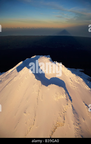 Prima luce sulla vetta del Monte taranaki Mt Egmont e Ombra Taranaki Isola del nord della Nuova Zelanda antenna Foto Stock