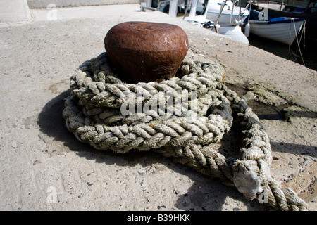 Un porto di attracco linea legato attorno un metallo bollard Foto Stock