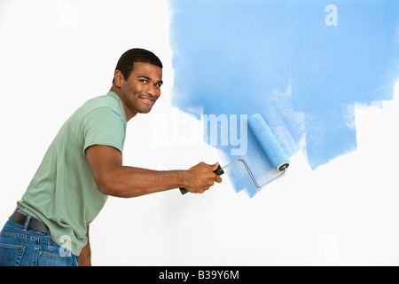 African American uomo muro dipinto blu sorridente al viewer Foto Stock