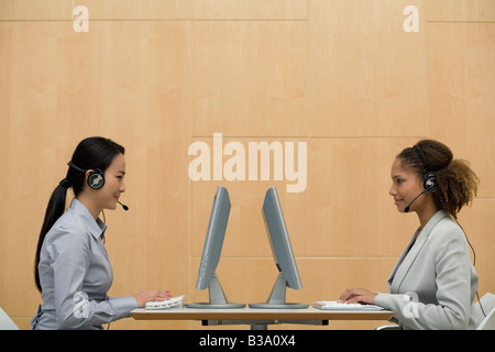 Multi-etnico imprenditrici indossando le cuffie Foto Stock