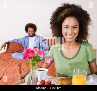 Donna africana che porta la colazione a letto il vassoio Foto Stock