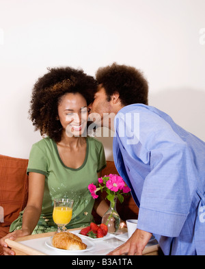 L'uomo africano portando la colazione a letto alla moglie Foto Stock
