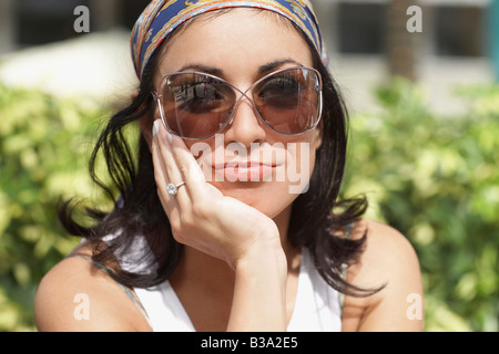 Donna ispanica indossando occhiali da sole Foto Stock