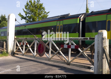 Treno che passa attraverso la strada Harling passaggio a livello ferroviario NORFOLK REGNO UNITO Foto Stock