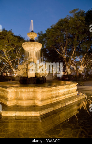 Central Plaza accesa al crepuscolo, la Antigua Guatemala (sito Unesco), Guatemala Foto Stock
