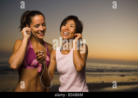 Multi-etnico amici ascolto stesso lettore mp3 Foto Stock