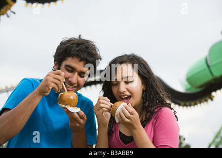 Multi-etnico adolescente giovane mangiare le mele candite Foto Stock