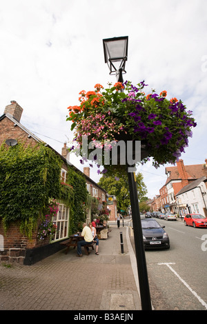 Regno Unito Cheshire Tarporley High Street i clienti seduti fuori Rising Sun Pub nella luce del sole Foto Stock