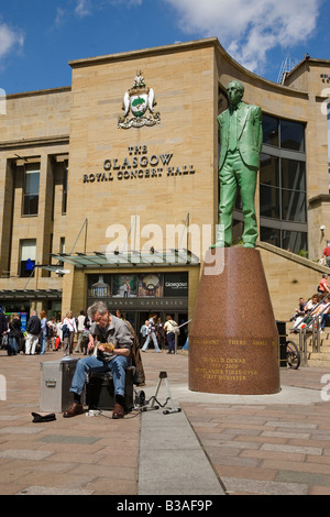 Busker a Buchanan Street Glasgow vicino alla statua di Donald Dewar, Primo Ministro per la Scozia Foto Stock