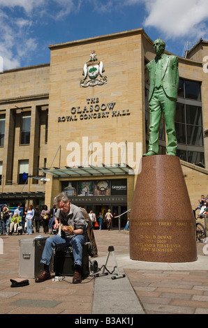 Busker a Buchanan Street Glasgow vicino alla statua di Donald Dewar, Primo Ministro per la Scozia Foto Stock
