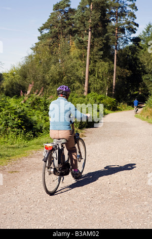 Regno Unito Cheshire Delamere Forest Park donna anziana ciclista sul gigante assistito elettricamente bike Foto Stock