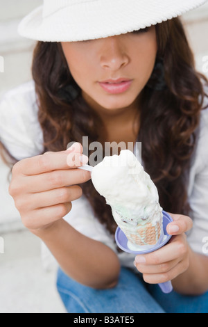 Donna ispanica a mangiare il gelato cono Foto Stock