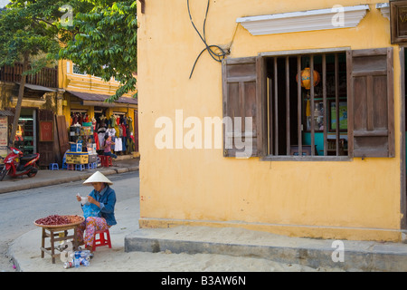 Una donna vietnamita vende il suo artigianato su un Hoi An angolo, Vietnam centrale Foto Stock