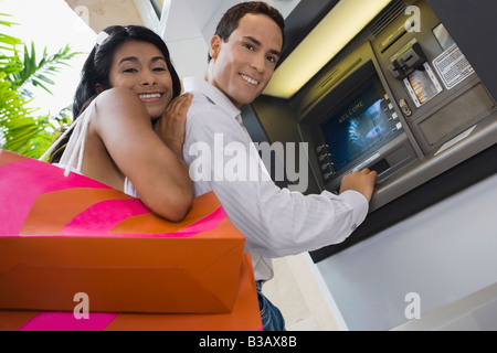 Coppia ispanica utilizza atm Foto Stock