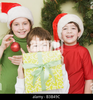 Fratelli di ispanici in Santa Claus cappelli con dono Foto Stock