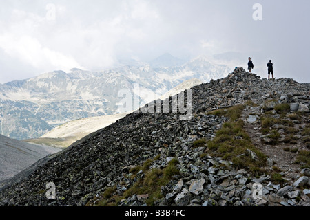 Due escursionisti sulla sommità del picco Polejan nel sito del Patrimonio Mondiale il Parco Nazionale di Pirin Bulgaria Foto Stock