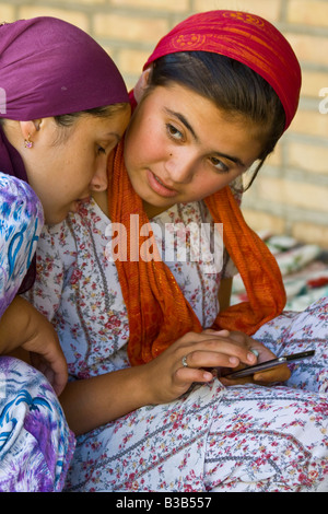 Giovani donne uzbeke utilizzando un iPod Touch di Apple a Bukhara Uzbekistan Foto Stock