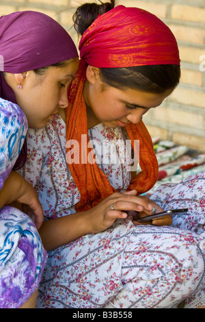 Giovani donne uzbeke utilizzando un iPod Touch di Apple a Bukhara Uzbekistan Foto Stock