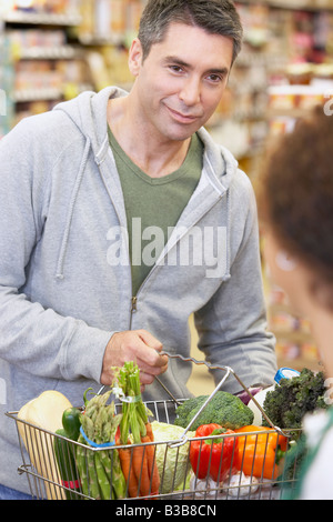 Uomo ispanico checking out al negozio di alimentari Foto Stock